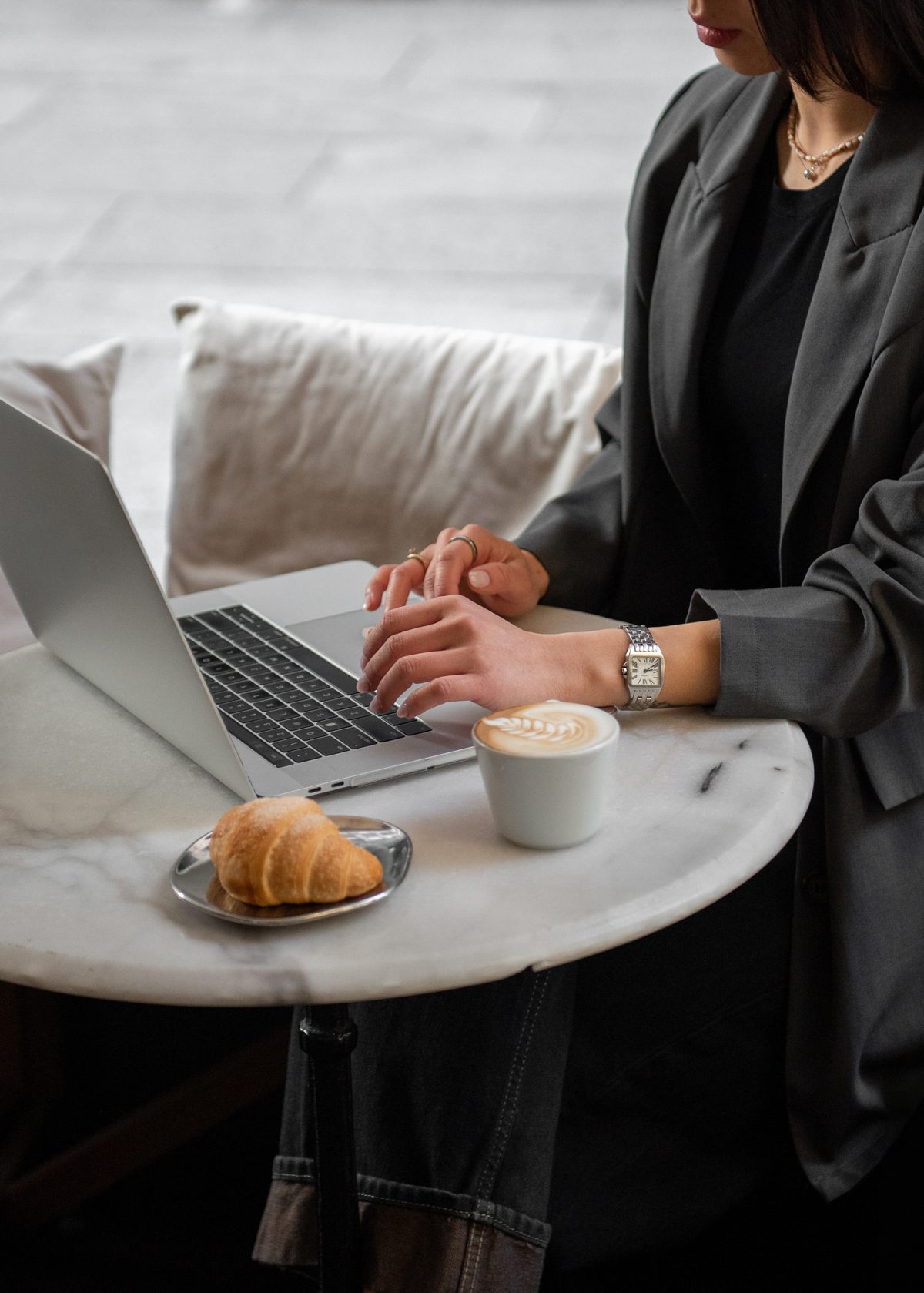 A salon owner planning her week with a coffee and laptop